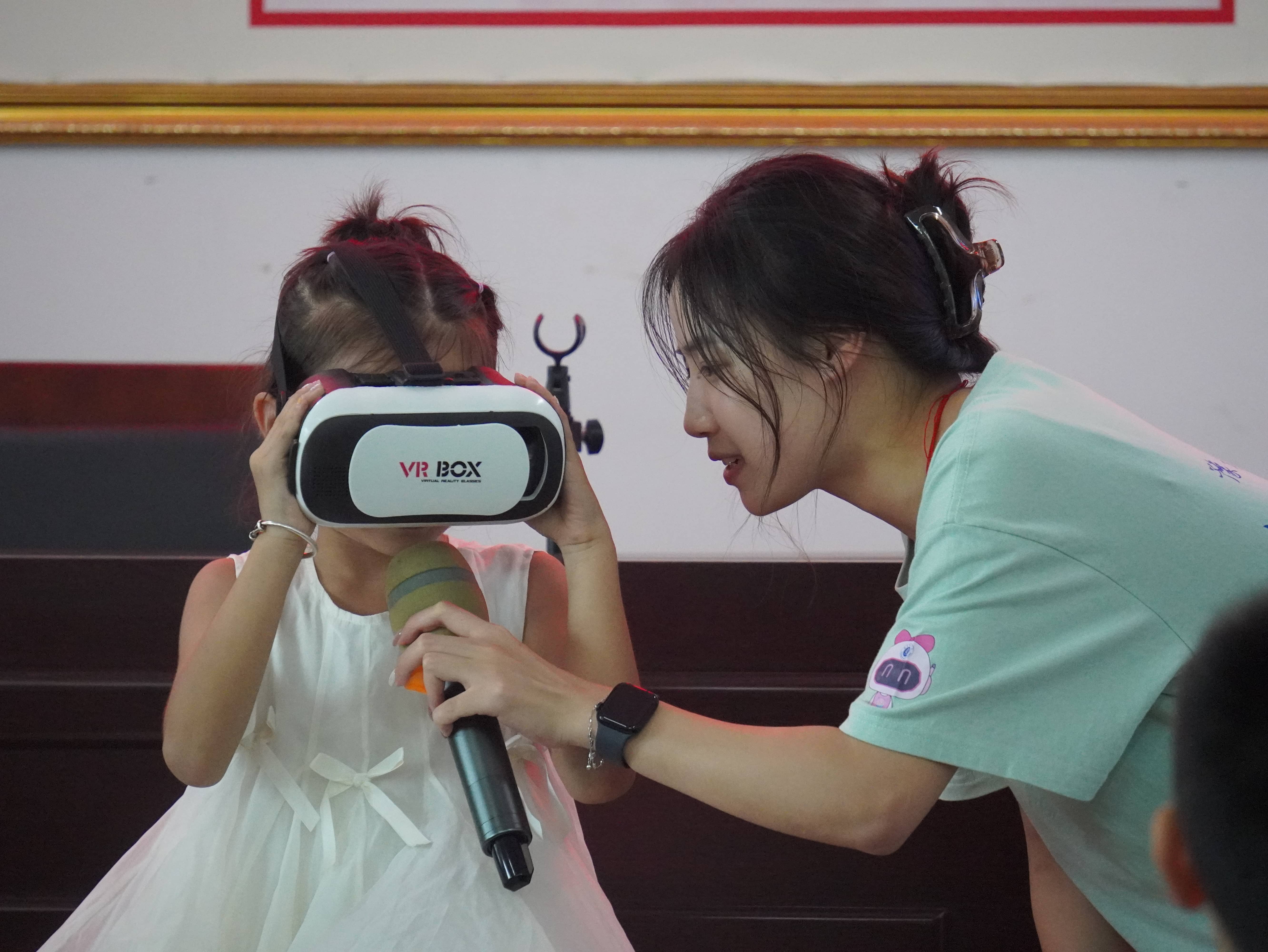 图5 实践队引导孩子们佩戴体验VR设备.JPG